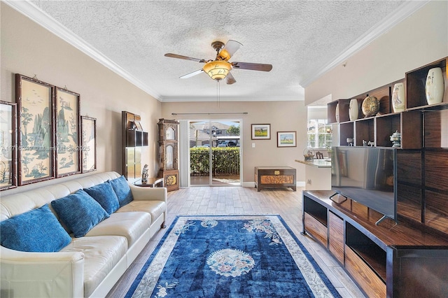 living room with ceiling fan, a textured ceiling, and ornamental molding