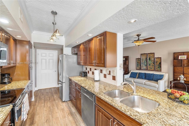 kitchen with appliances with stainless steel finishes, a textured ceiling, ceiling fan, crown molding, and sink