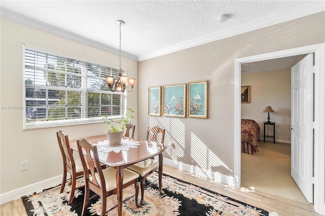 dining area featuring a textured ceiling, an inviting chandelier, and ornamental molding