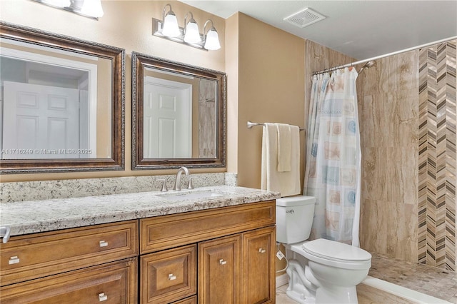 bathroom with a shower with shower curtain, vanity, toilet, and tile patterned flooring