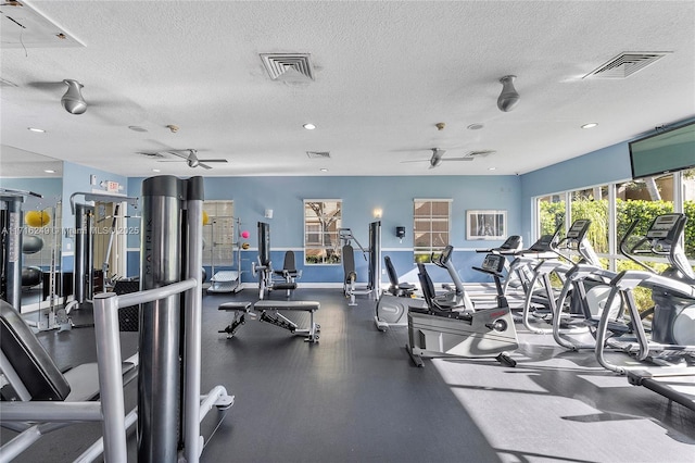 gym featuring ceiling fan and a textured ceiling