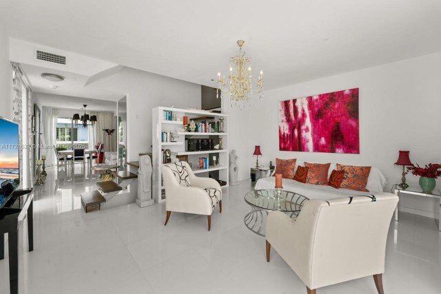 living room with a chandelier and light tile patterned flooring