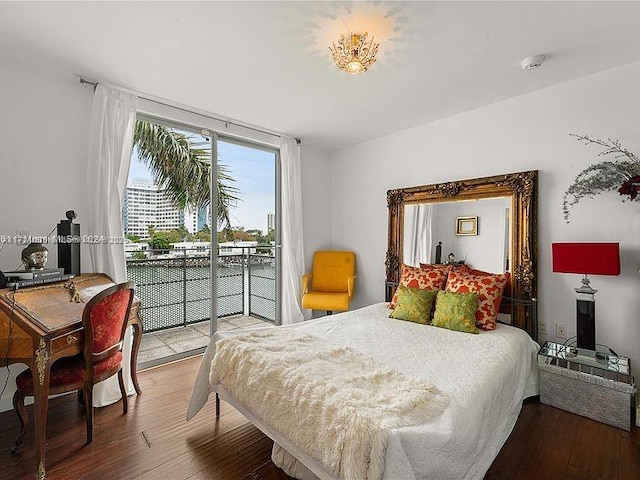 bedroom with a wall of windows, access to outside, and hardwood / wood-style flooring