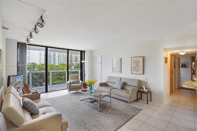 tiled living room featuring a textured ceiling, track lighting, and expansive windows