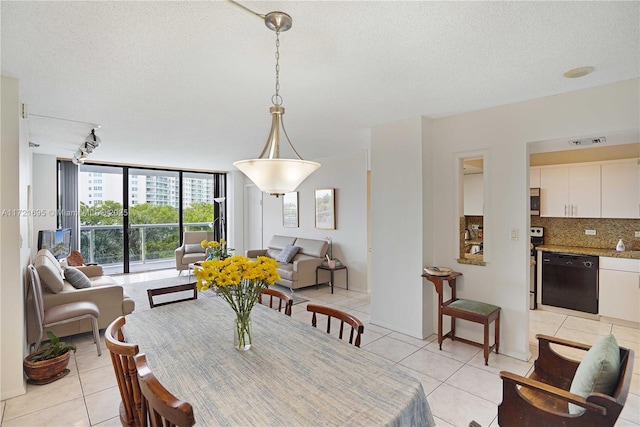 dining room with floor to ceiling windows, a textured ceiling, light tile patterned floors, and track lighting