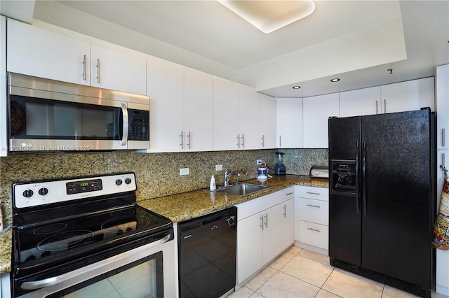 kitchen with black appliances, sink, light tile patterned flooring, white cabinetry, and dark stone counters