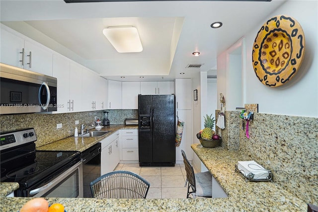 kitchen with decorative backsplash, light tile patterned flooring, black appliances, white cabinets, and sink