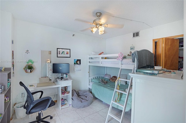 bedroom featuring a textured ceiling, ceiling fan, and light tile patterned floors