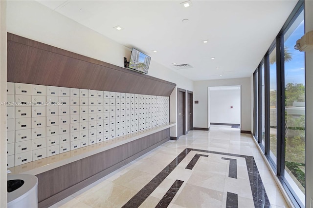 hallway featuring mail boxes and a wall of windows