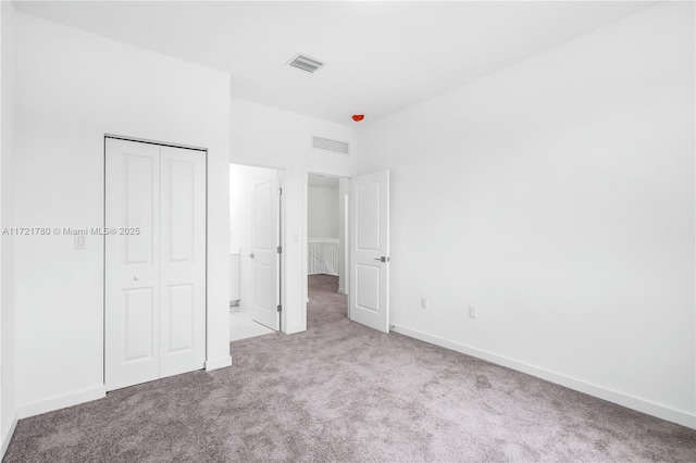 unfurnished bedroom featuring a closet and light colored carpet