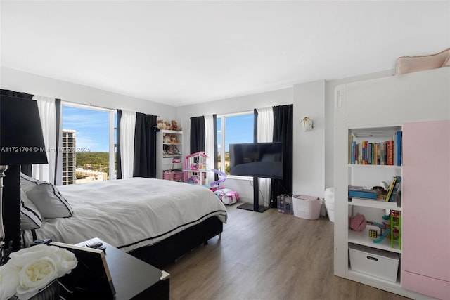 bedroom with hardwood / wood-style flooring and multiple windows