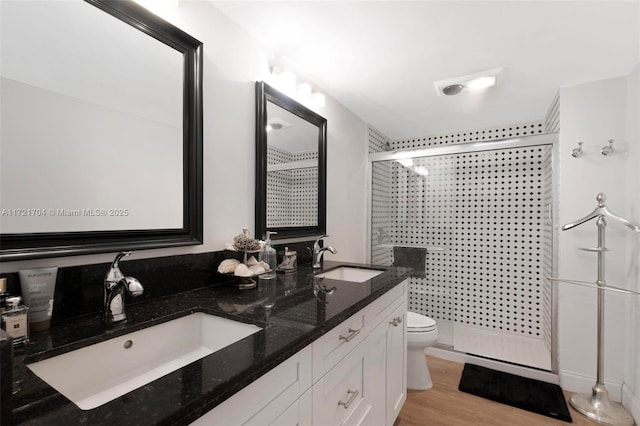 bathroom featuring hardwood / wood-style floors, vanity, an enclosed shower, and toilet