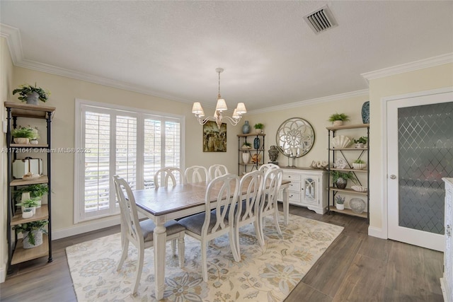 dining room with a textured ceiling, dark hardwood / wood-style flooring, an inviting chandelier, and crown molding