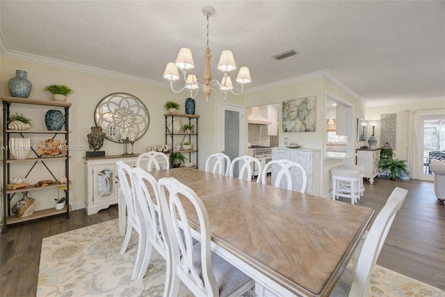 dining area with a chandelier, crown molding, and dark wood-type flooring