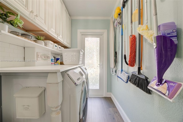 laundry area with separate washer and dryer, cabinets, crown molding, and wood-type flooring