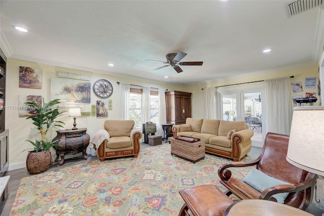 living room featuring wood-type flooring, ceiling fan, and ornamental molding