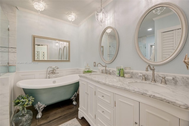 bathroom featuring a tub, ornamental molding, vanity, and hardwood / wood-style floors