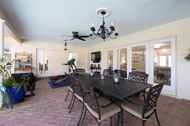 dining area with ceiling fan with notable chandelier, french doors, and a wealth of natural light