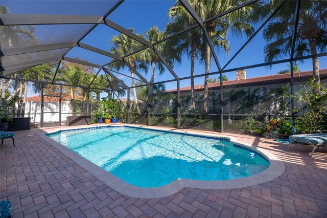 view of swimming pool with a patio and glass enclosure