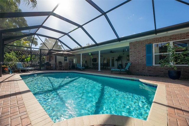 view of pool with a lanai, a patio area, and ceiling fan