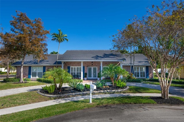 ranch-style house featuring french doors and a front lawn