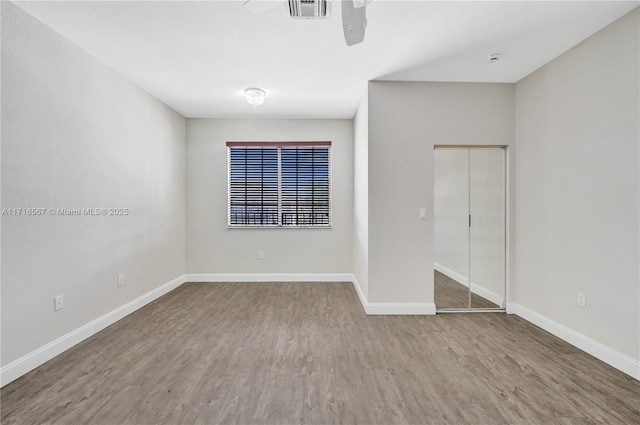 unfurnished bedroom with hardwood / wood-style floors, ceiling fan, and a closet