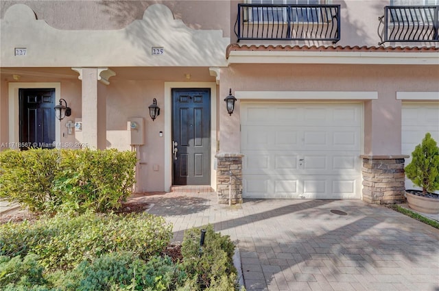 property entrance featuring a balcony and a garage