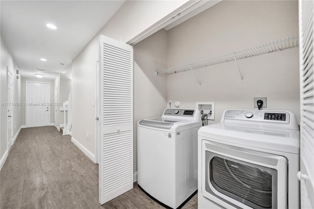 laundry room with washer and clothes dryer and light hardwood / wood-style floors