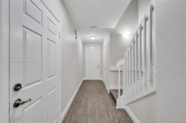 corridor with light hardwood / wood-style floors