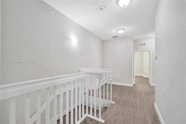 corridor with hardwood / wood-style flooring