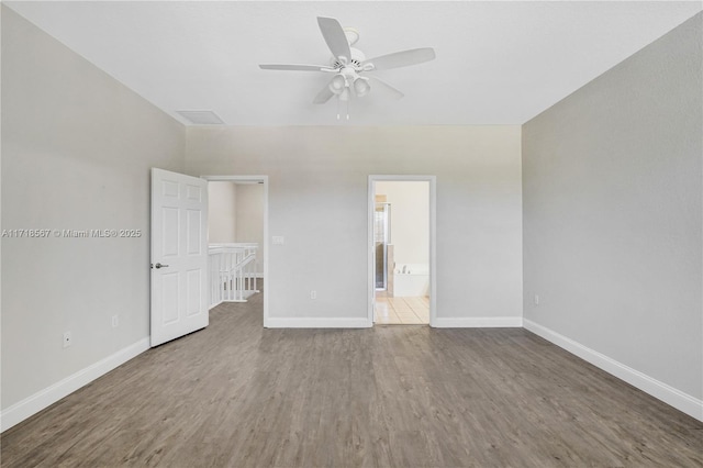 unfurnished bedroom featuring wood-type flooring, ensuite bath, and ceiling fan