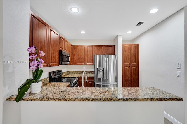 kitchen featuring light stone countertops, stainless steel appliances, kitchen peninsula, and sink