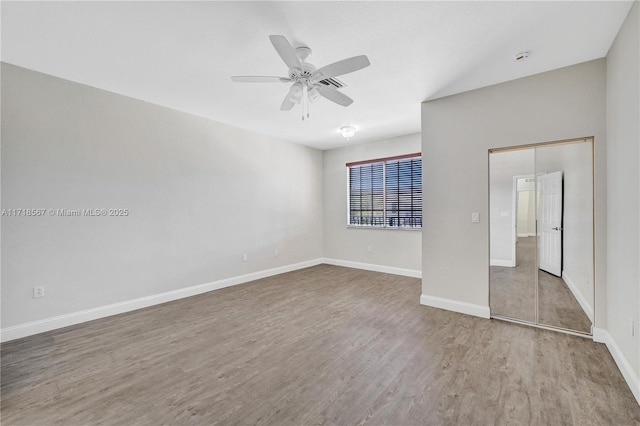 unfurnished bedroom featuring ceiling fan, a closet, and light wood-type flooring