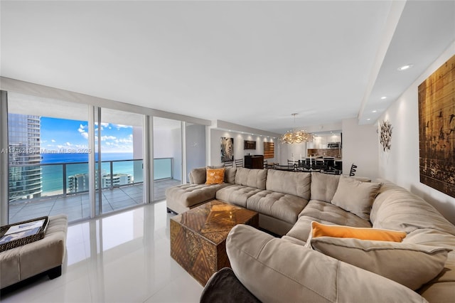 tiled living room with a water view, an inviting chandelier, and a wall of windows