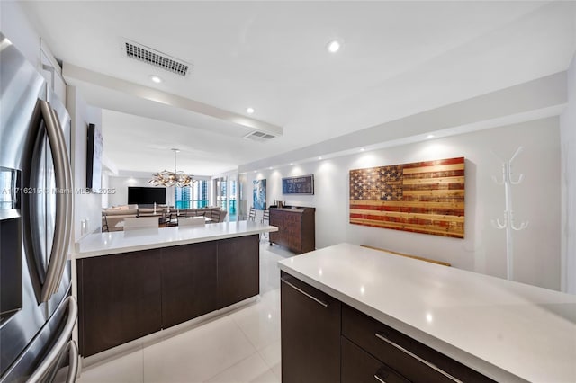 kitchen with a chandelier, stainless steel fridge, dark brown cabinetry, and light tile patterned floors