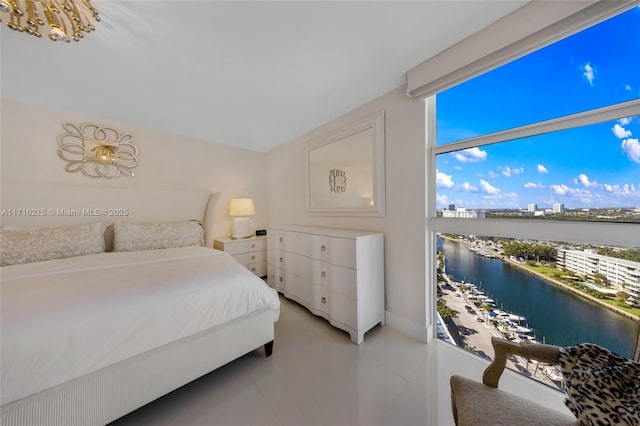 bedroom with a water view and light tile patterned floors