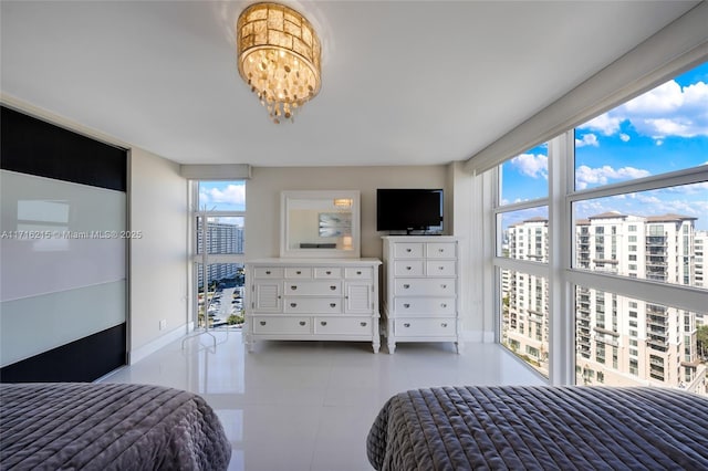 bedroom featuring multiple windows, light tile patterned floors, floor to ceiling windows, and a notable chandelier