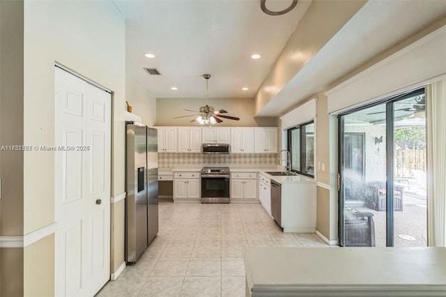 kitchen featuring white cabinets, sink, light tile patterned floors, tasteful backsplash, and stainless steel appliances