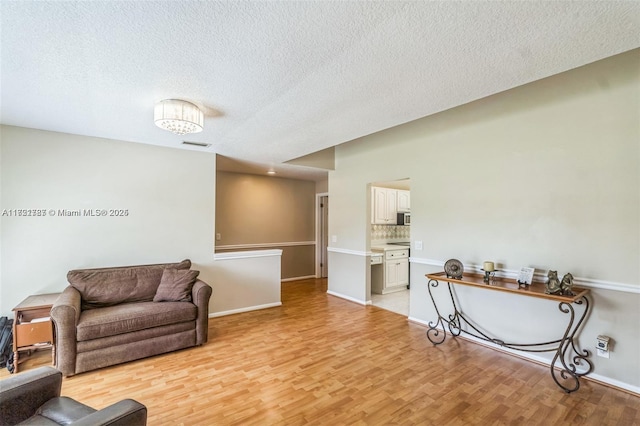 living room with a textured ceiling and light hardwood / wood-style flooring