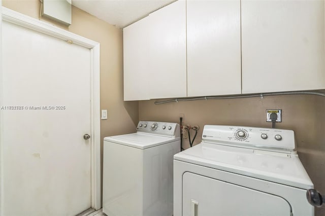 laundry room featuring cabinets and washing machine and dryer