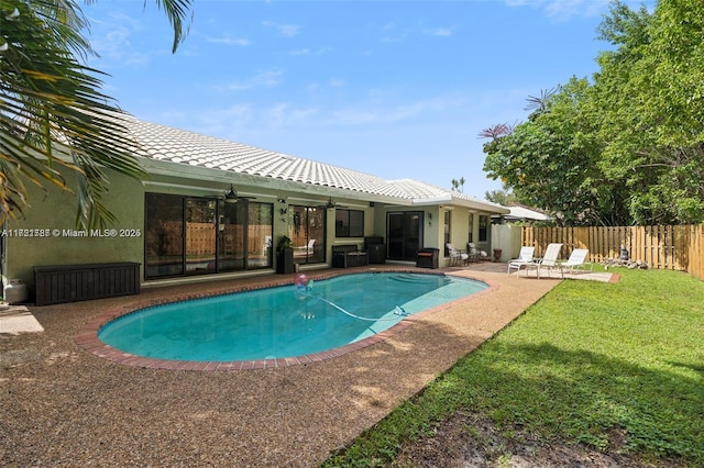 view of swimming pool with a lawn, ceiling fan, and a patio area