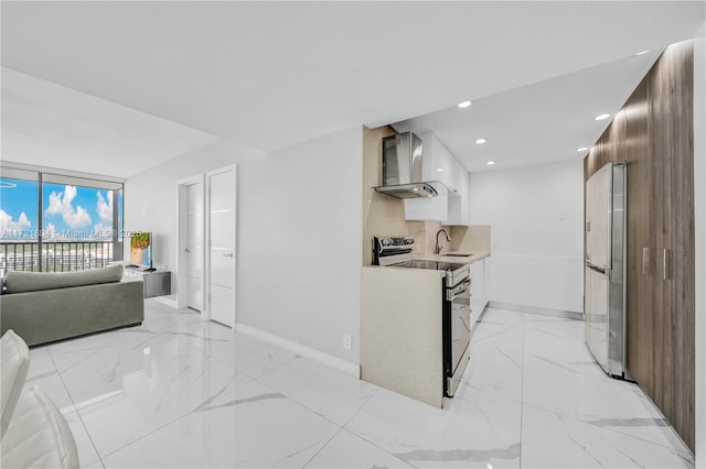 kitchen with white cabinetry, sink, stainless steel appliances, wall chimney range hood, and backsplash