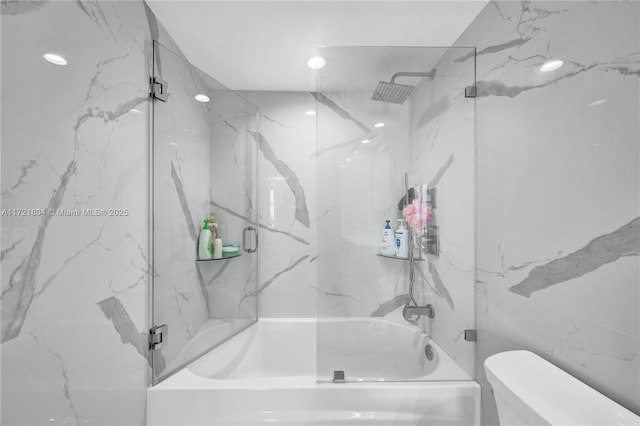 bathroom featuring shower / bath combination with glass door and toilet