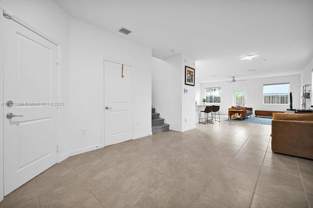 unfurnished living room with ceiling fan and light tile patterned floors