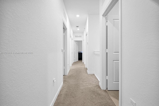 hallway with light colored carpet