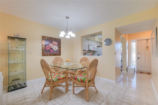 dining room with light tile patterned floors, a textured ceiling, and an inviting chandelier