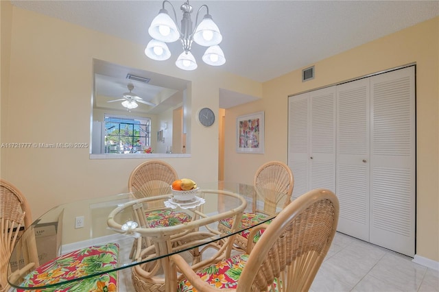 tiled dining space featuring ceiling fan with notable chandelier