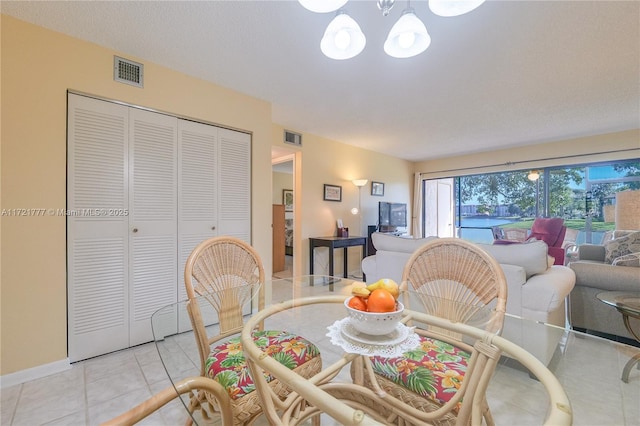 tiled dining area featuring an inviting chandelier