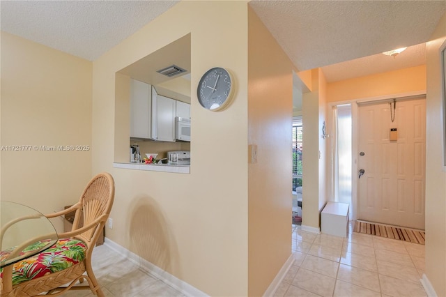 tiled entryway featuring a textured ceiling