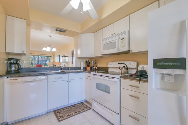 kitchen with white cabinetry, sink, white appliances, light tile patterned floors, and ceiling fan with notable chandelier